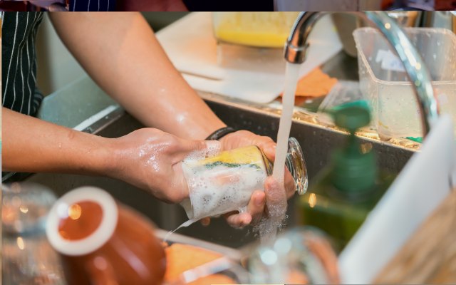 Someone washing up at a sink