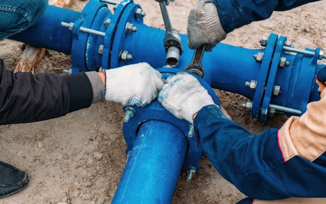 A close up of workers installing a new pipe