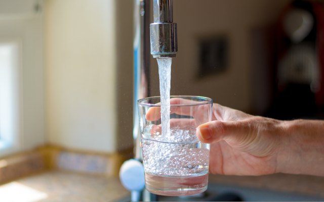 Tap water flowing into a drinking glass