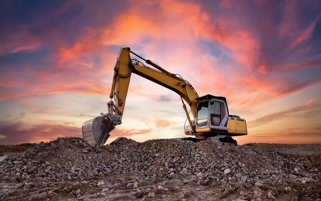 A digger framed by a rosy sky